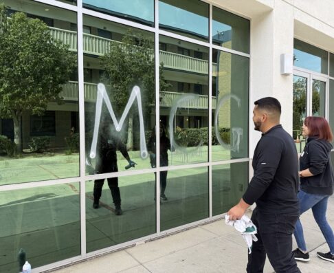 mcg employee cleaning a window