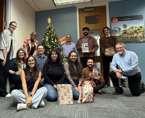 mcg employees gathered by a christmas tree