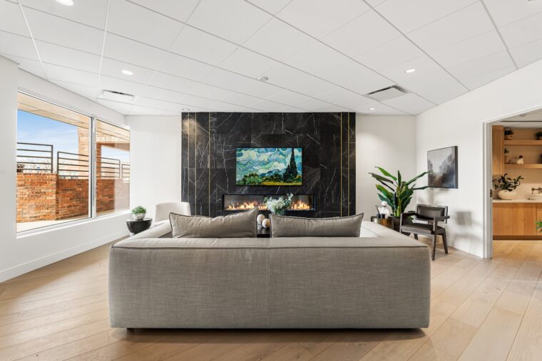 A couch and fireplace at The Orchard Spinal Clinic